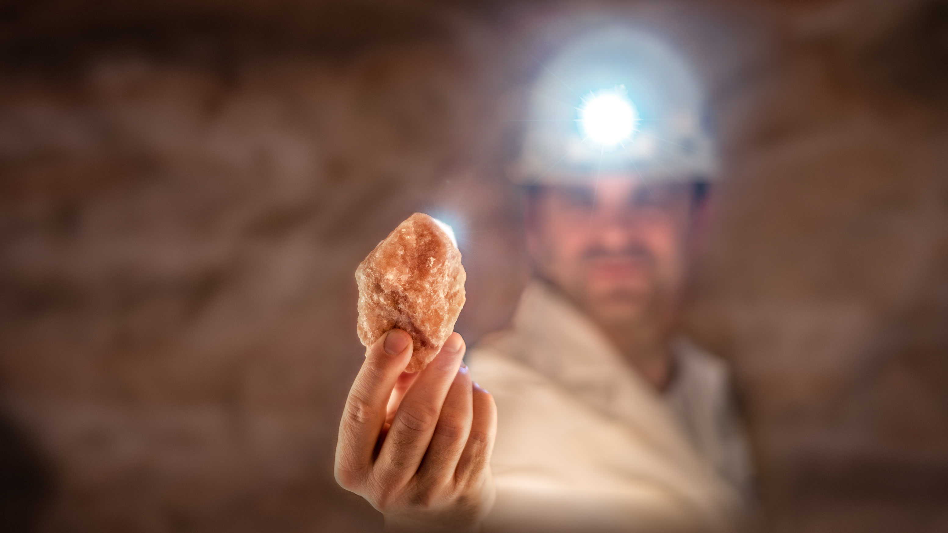 Bergarbeiter begutachtet Salzkristall unter Tage
